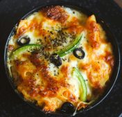 Delicious cheesy baked pasta with black olives and peppers, perfect for a cozy meal.