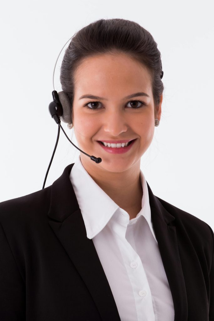 Confident female call center agent smiling at the camera with a headset.
